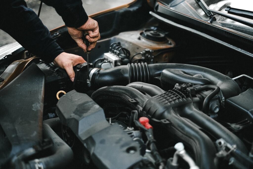 An Auto Mechanic Checking the Engine of a Car